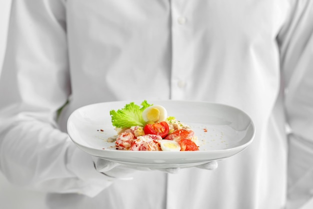 Kucharz prezentuje talerz jedzenia